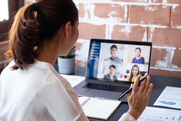 Eine junge Frau sitzt in einem virtuellen Vorstellungsgespräch am Laptop.