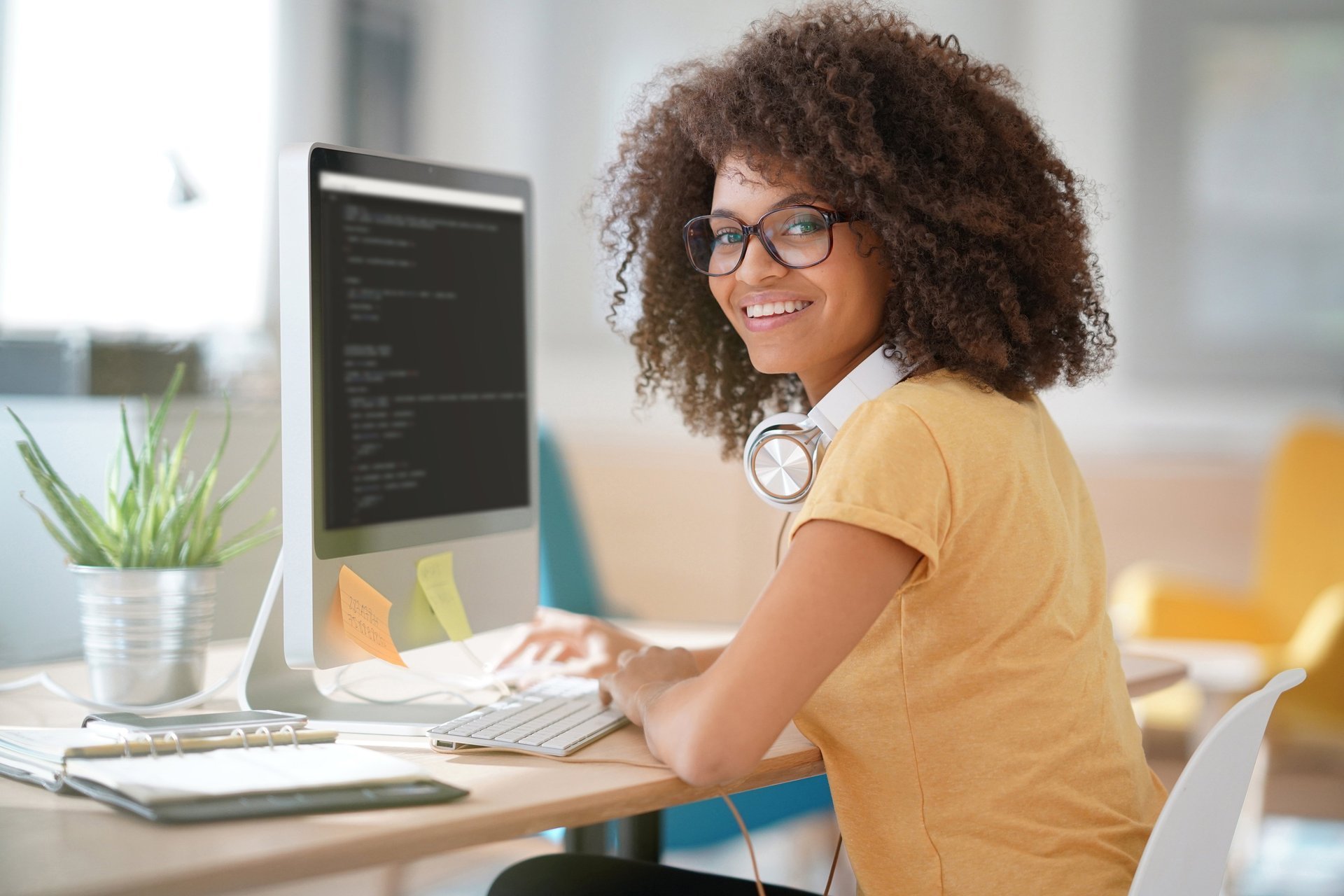 EIne junge Frau sitzt an einem Computer.