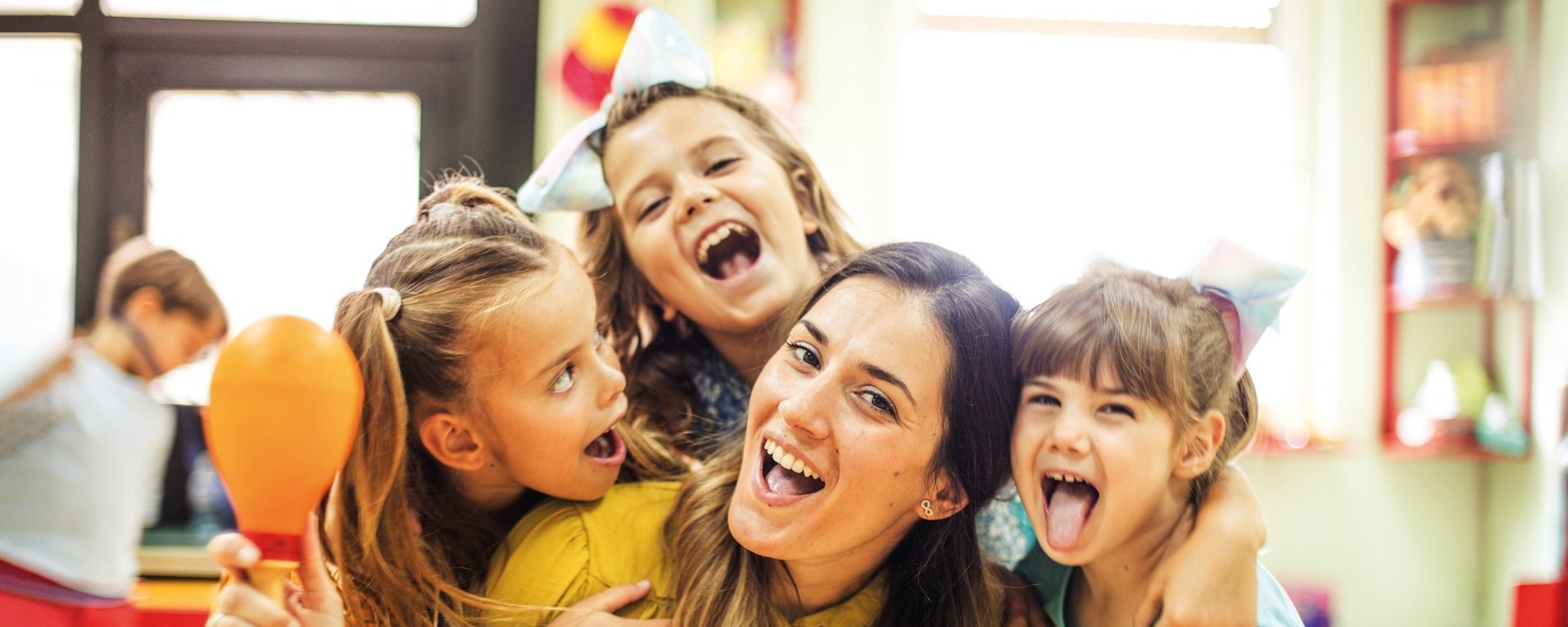 Eine Erzieherin spielt mit Kindern in einem Kindergarten