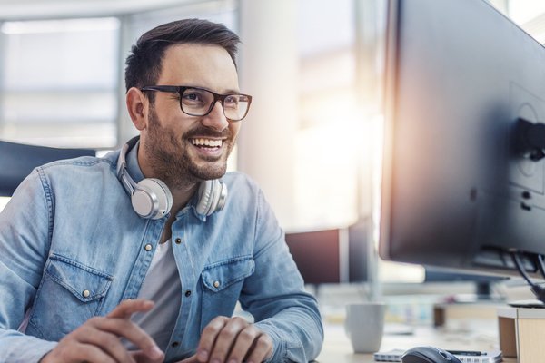 Ein Kaufmann im Digitalisierungsmanagement sitzt an einem Schreibtisch und arbeitet.