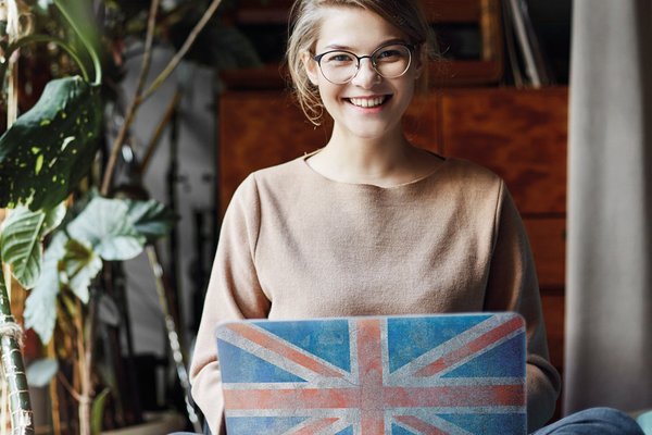 Eine Frau sitzt an ihrem Laptop, der mit dem Union Jack bedruckt ist.