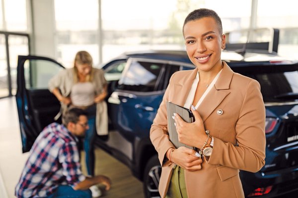 Eine Automobilkauffrau steht in einem Verkaufsraum