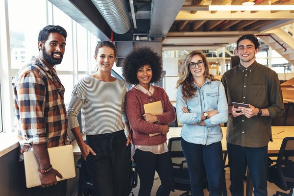 Eine integrative Gruppe Menschen steht zusammen in einem Büro.