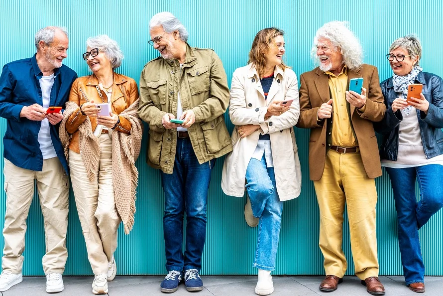 Eine Gruppe Menschen lehnt an einer türkisfarbenen Wand.