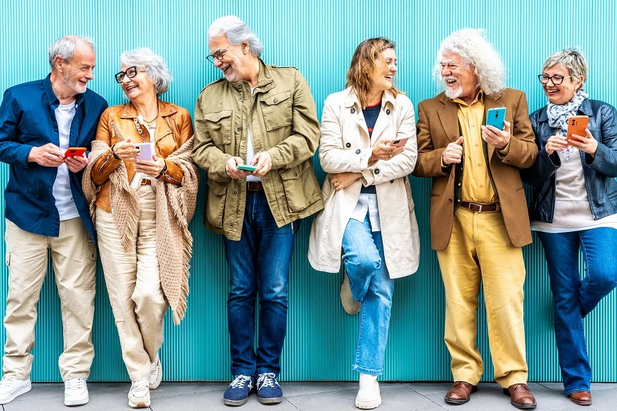 Eine Gruppe Menschen lehnt an einer türkisfarbenen Wand.